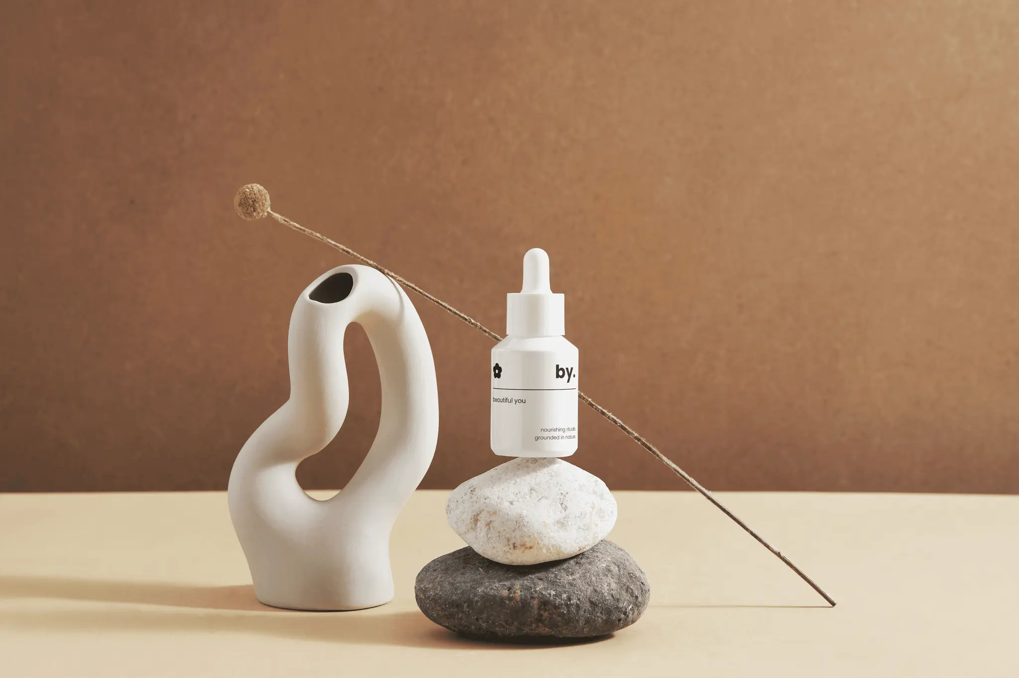 dropper bottle staged for photo on rocks